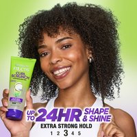 Woman smiling, holding Garnier Fructis Curl Scrunch Gel, 'Up to 24HR Shape & Shine' text.