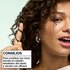 Hair styling tip: woman demonstrating how to wrap hair around a finger and diffuse for perfectly constructed curls using Garnier Fructis mousse.