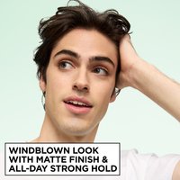 A young man with dark, effortlessly styled hair. Text below reads "WINDBLOWN LOOK WITH MATTE FINISH & ALL-DAY STRONG HOLD".