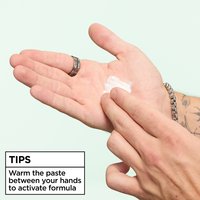 A close-up of a hand with a dollop of paste being warmed by another hand. Text at the bottom reads "TIPS: Warm the paste between your hands to activate formula".