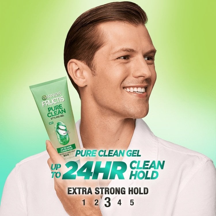A man with slicked-back hair holding the Garnier Fructis Pure Clean Styling Gel. This gel offers up to 24 hours of clean hold.
