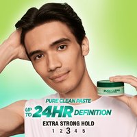 A man with slicked-back hair holding the Garnier Fructis Pure Clean Finishing Paste. This paste offers up to 24 hours of definition.