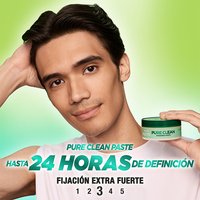 A man with slicked-back hair holding the Garnier Fructis Pure Clean Finishing Paste. This paste offers up to 24 hours of definition.