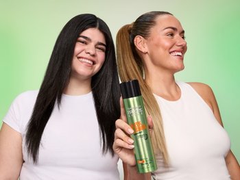 Two women smiling holding the Sleek & Shine Hairspray.