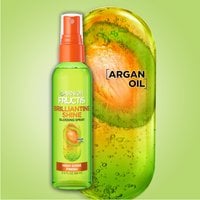 Shot of Brilliantine Shine Glossing Spray bottle next to a representation of an argan oil molecule.