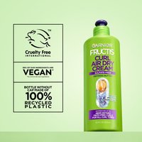 Garnier Fructis Curl Air Dry Cream bottle alongside a panel detailing "Cruelty Free International" certification, "99% Vegan" ingredients, and "100% Recycled Plastic" bottle.