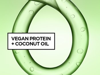 A macro close-up of a transparent green, circular hair product texture. A text box overlay in the center reads: "VEGAN PROTEIN + COCONUT OIL".