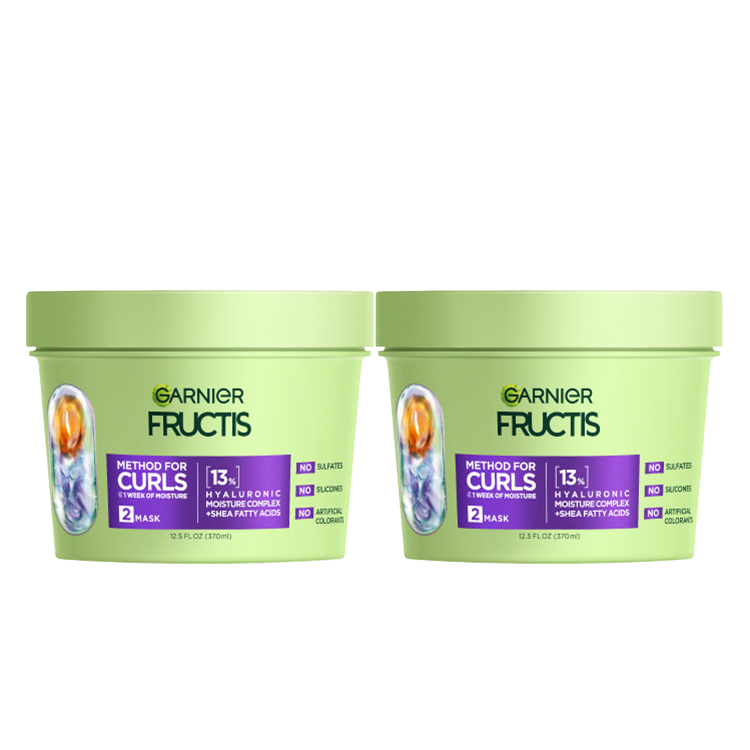 Two light green tubs of Garnier Fructis Method for Curls Mask are displayed. Each tub is labeled "METHOD FOR CURLS UP TO 1 WEEK OF MOISTURE," indicating it's a "MASK" with "13% HYALURONIC MOISTURE COMPLEX + SHEA FATTY ACIDS." It also states "NO SULFATES, NO SILICONES, NO ARTIFICIAL COLORANTS."