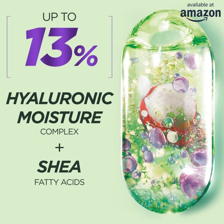 A close-up visual highlighting the main ingredients of the product: "UP TO 13% HYALURONIC MOISTURE COMPLEX + SHEA FATTY ACIDS." A large, stylized image of the product's ingredient capsule, filled with translucent bubbles and a red element, is on the right. The "available at amazon" logo is in the top right.