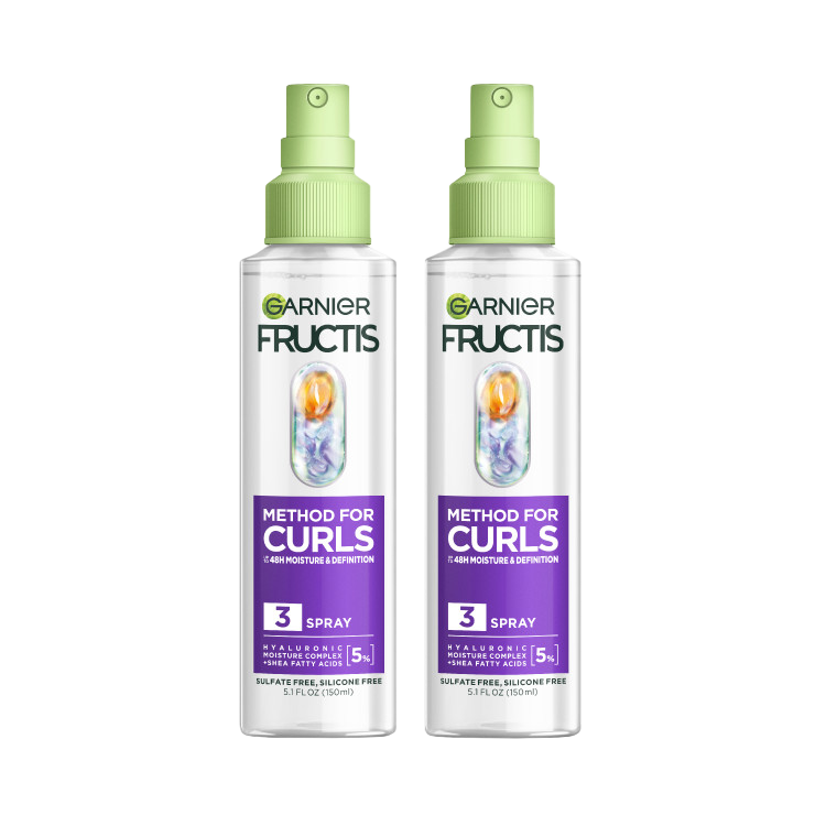Two clear spray bottles with light green tops and nozzles, featuring Garnier Fructis Method for Curls Spray. Each bottle highlights "48H Moisture & Definition," contains "HYALURONIC MOISTURE COMPLEX + SHEA FATTY ACIDS [5%]," and is "SULFATE FREE, SILICONE FREE."