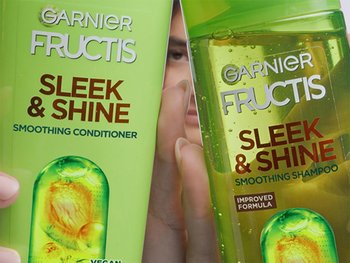 One bottle of shampoo (right) and conditioner (left) from the Garnier Sleek & Shine collection.