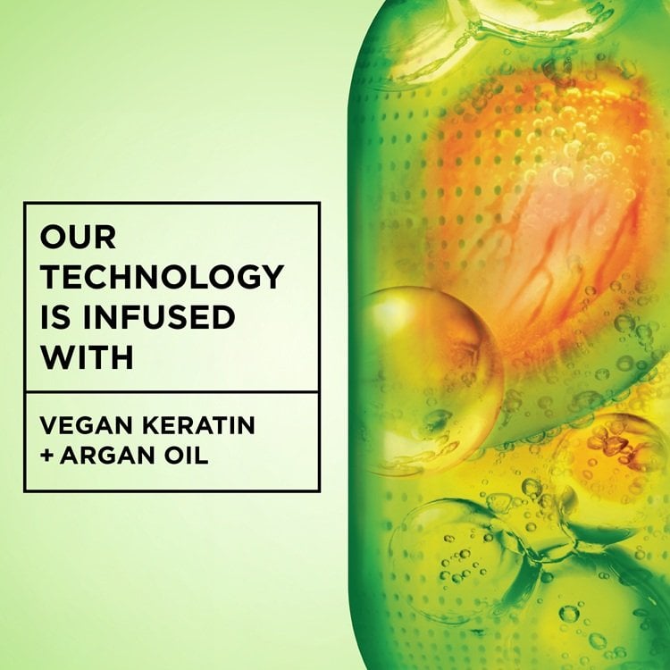 A green capsule-like illustration with inner components and bubbles, accompanied by text detailing that the technology is infused with "VEGAN KERATIN" and "ARGAN OIL."