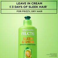 Close-up of an XL bottle of Garnier Fructis Sleek & Shine Leave-In Conditioner, with text that claims "Up to 3 days of sleek hair with system of Sleek & Shine Shampoo, Conditioner and Leave-in Cream. For frizzy, dry hair".