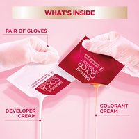 Hands in gloves mixing the "Developer Cream" and "Colorant Cream" from small packets.