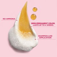 A close-up of the thick, white cream formula with droplets of golden oil. Text mentions "NO AMMONIA" and "SHAMPOO-LIKE APPLICATION."
