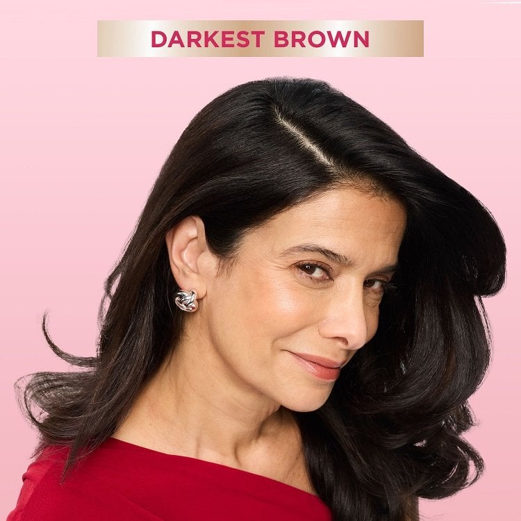 A smiling woman with long, smooth dark brown hair, looking directly at the viewer. A banner at the top indicates ‘Darkest Brown,' suggesting a hair color result.
