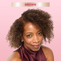 A smiling woman with shoulder-length, curly brown hair, looking directly at the viewer. A banner at the top indicates ‘Brown,' suggesting a hair color result.