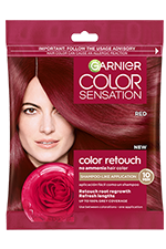 A small, single-use packet of Garnier Color Sensation Root Retouch in Red, featuring a woman with red hair and a red rose.