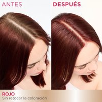 A 'Before and After' comparison showing the top of a woman's head. The 'Before' image displays visible light brown hair at the roots along her part, while the 'After' image shows her hair uniformly dyed red with no brown roots visible.