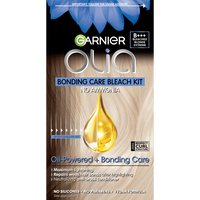 Garnier Olia Bonding Care Bleach Kit box displayed against a soft white background. The packaging features a navy blue and white design with the gold Olia logo prominently centered. Blue botanical flowers appear in the upper left corner, and a golden oil drop icon is visible alongside the text "Oil-Powered + Bonding Care." A shade swatch strip runs along the left edge of the box.