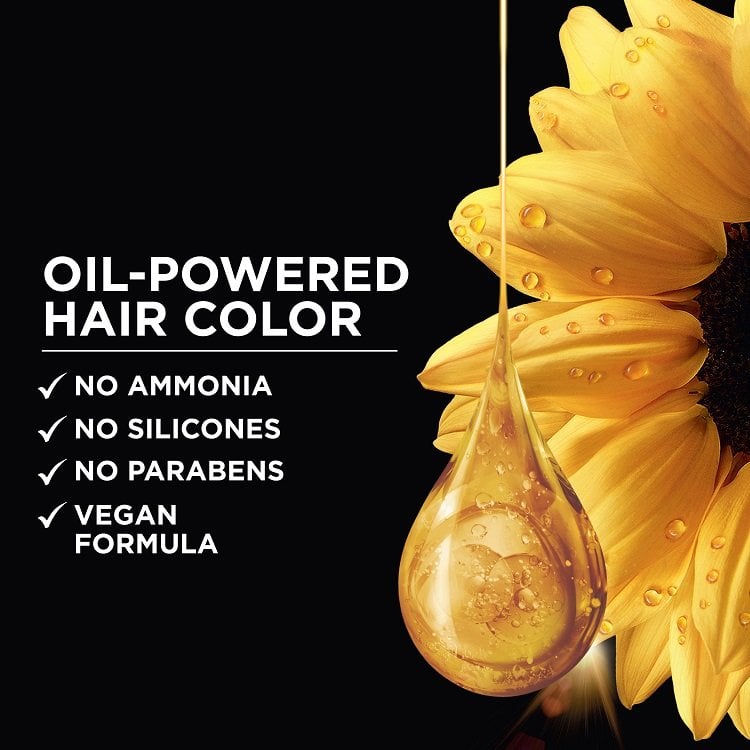 Close-up of a drop of golden oil falling from a sunflower petal, highlighting the oil-powered formula of Garnier Olia hair color.