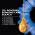 Dark navy promotional graphic for Garnier Olia featuring a large, glistening golden oil droplet at center-right with soft blue flowers in the background. Bold white headline text reads: "OIL POWERED BONDING CARE BLEACH." Below, a bulleted checklist in white reads: "✓ No Ammonia ✓ No Silicones ✓ No Parabens ✓ Vegan Formula."