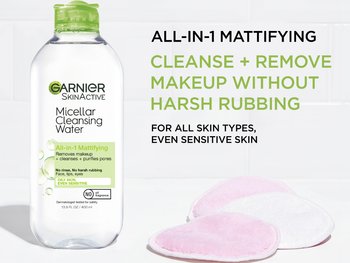 Garnier SkinActive Micellar Cleansing Water, All-in-1 Mattifying, with a green cap, 400ml bottle, cleanses, removes makeup, and purifies pores for oily, sensitive skin. Two pink reusable pads are visible on the right.