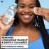 Smiling woman with braided hair using a cotton pad and micellar water bottle, captioned "Removes Longwear Makeup & Gently Cleanses."