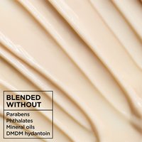 Macro texture shot of rich Garnier Whole Blends Honey Treasures conditioner: a vegan formula blended without parabens, phthalates, mineral oils, or DMDM hydantoin.