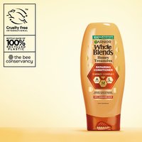 Garnier Whole Blends Honey Treasures Repairing Conditioner hero shot: highlighting the vegan formula, cruelty-free certification, and 100% recycled plastic bottle.
