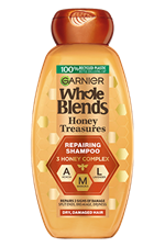 Garnier Whole Blends Honey Treasures Repairing Shampoo bottle for dry, damaged hair: 12.5 fl oz packaging featuring a 3 honey complex of acacia, manuka, and lavender honey to repair split ends, breakage, and dryness.