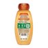 Back view of Garnier Whole Blends Honey Treasures Repairing Shampoo bottle: showing full ingredient list, directions for use, and greener beauty commitments including responsible sourcing.