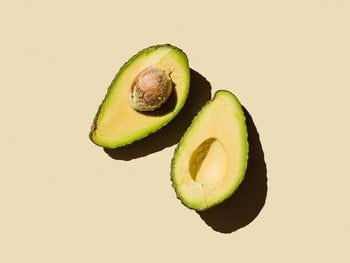 Two halves of a ripe avocado, showcasing the rich source of nutrients beneficial for skin and hair health when consumed or used topically as oil.