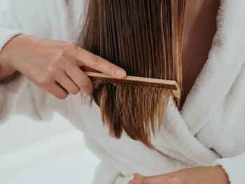 Brushing long hair with a comb.