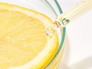 A close-up of a dropper with a lemon slice.