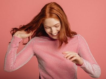A person with fine, straight hair applies argan oil, demonstrating its use for this specific hair type.