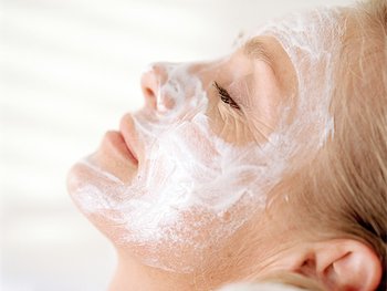 A person relaxing with a white, creamy face mask applied to their skin, highlighting a nourishing and rejuvenating skincare treatment or spa experience.