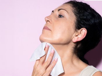 A person uses a makeup wipe to remove makeup, illustrating the standard use of the product.