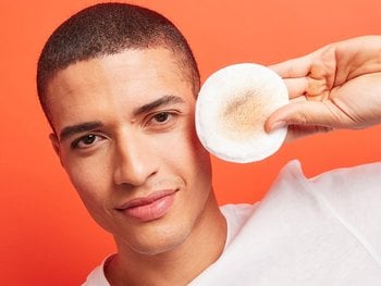 Person applying toner with a cotton pad.
