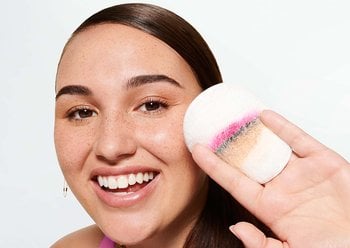 Woman holding an eco pad with makeup on it