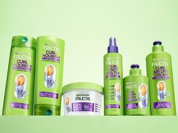 A collection of Garnier Fructis Curl Nourish products, including shampoo, conditioner, Flexi-Hold Curls, Curl Knot Melter, and Curl Air Dry Cream.